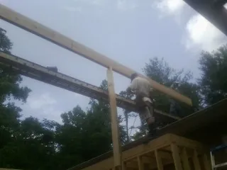 Carpenter setting a ridge beam over a new addition frame — Ice Dam Removal by Roofing Brothers in Cornwall Bridge