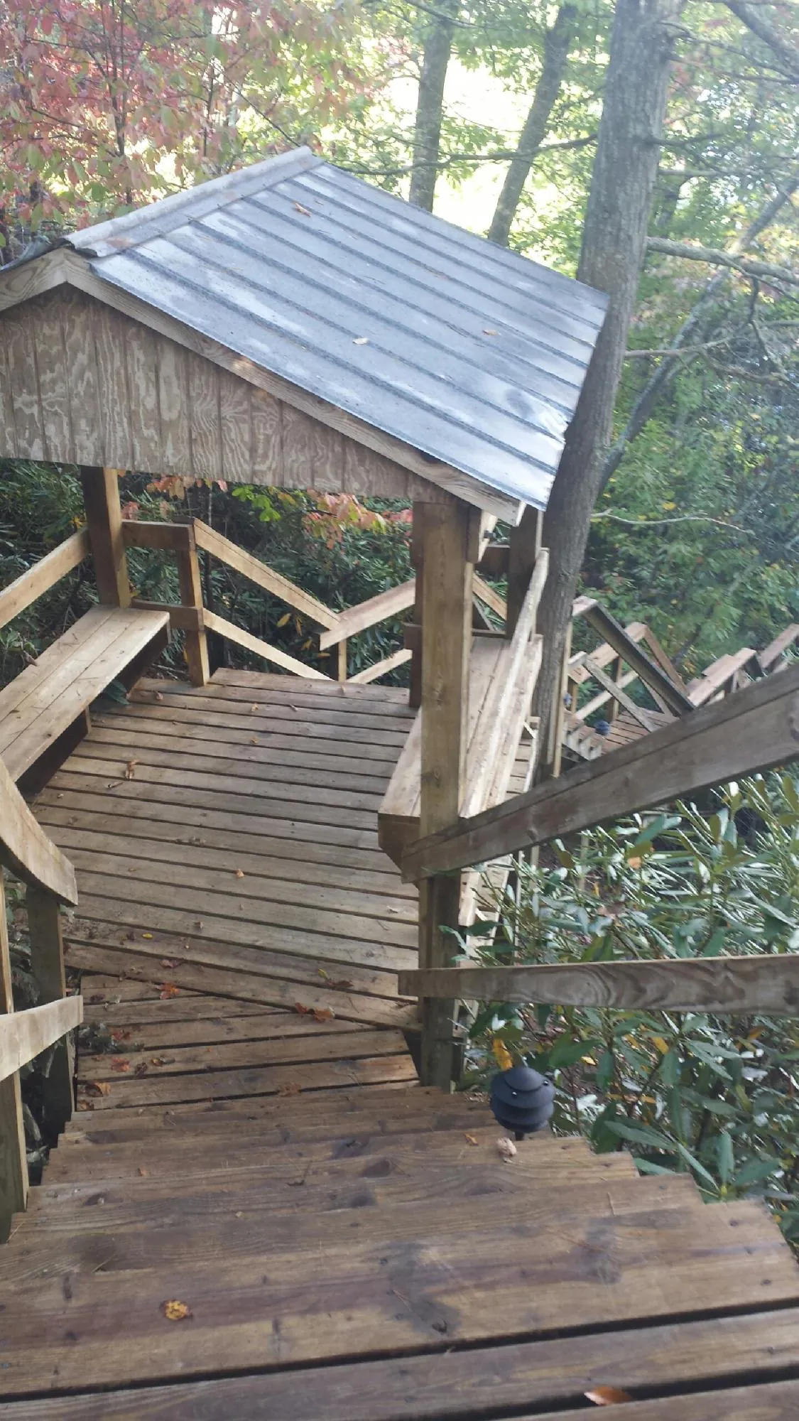 Metal roofed shelter over wooden steps on a wooded walkway — Skylight Repair & Installation work by our crew in Cornwall Bridge