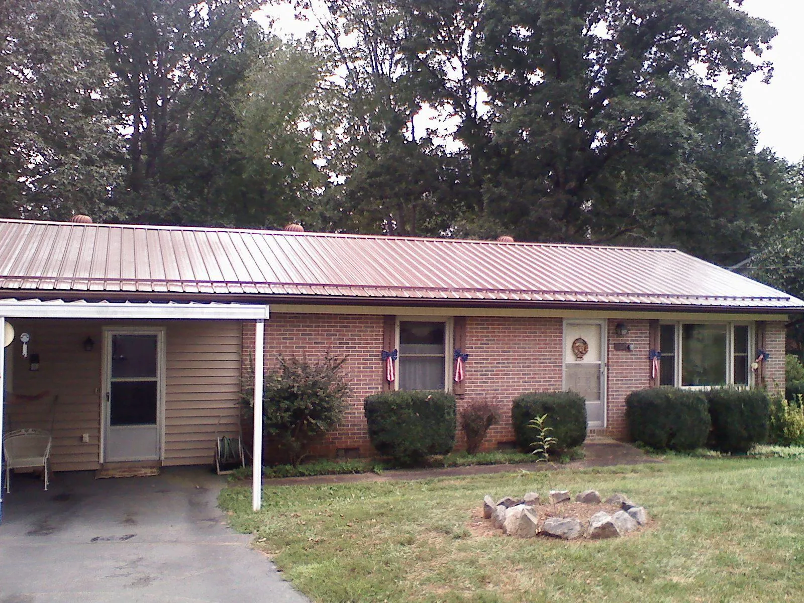 Bronze metal roof and carport on a brick ranch home — Roof Repair work by our crew in Cornwall Bridge